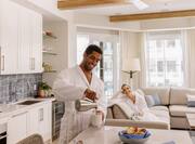 couple pouring coffee in guest room