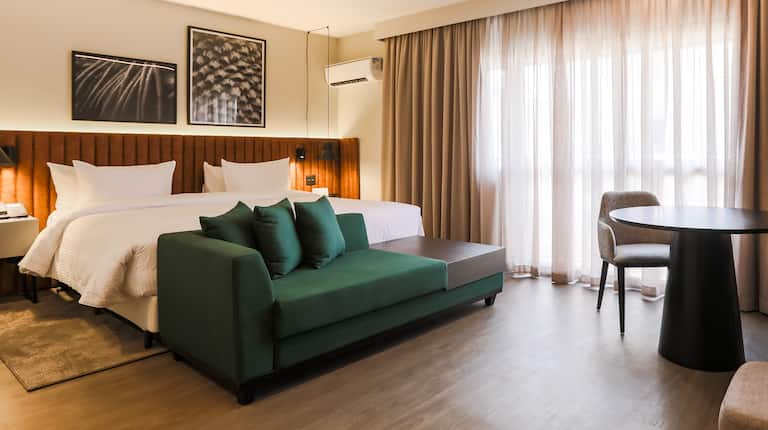 Zimmer mit Queensize-Bett, weichem Sitz und rundem Tisch