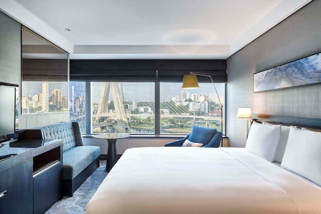 Zimmer mit Kingsize-Bett, komfortablen Stühlen und Fernseher