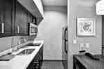 Suite Kitchen With Sink, Cooktop Stove, Microwave, and Refrigerator