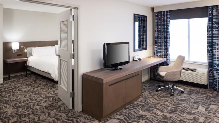 Separate Living Room with TV and Work Desk in King Whirlpool Suite