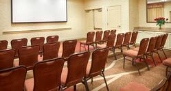 Meeting Room Arranged Theater Style With Rows of Chairs Facing Projector Screen