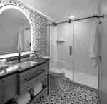 Bathroom Vanity Area with Large Mirror and a Glassdoor Shower