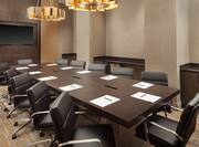Salon A2 Meeting Room with Long Conference Table and Leather Chairs with Flatscreen on Wall