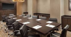Salon A2 Meeting Room with Long Conference Table and Leather Chairs with Flatscreen on Wall
