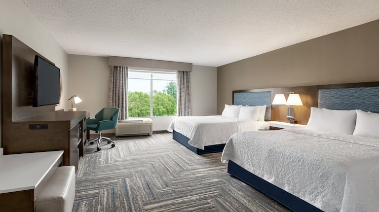 Spacious accessible guestroom featuring two comfortable queen beds, work desk, and beautiful outside view.