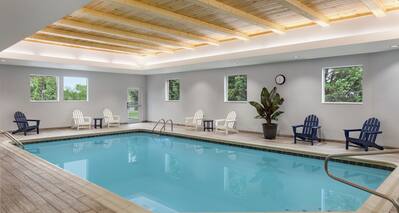 Stunning indoor pool featuring ample seating, cedar ceiling, and beautiful outside views.