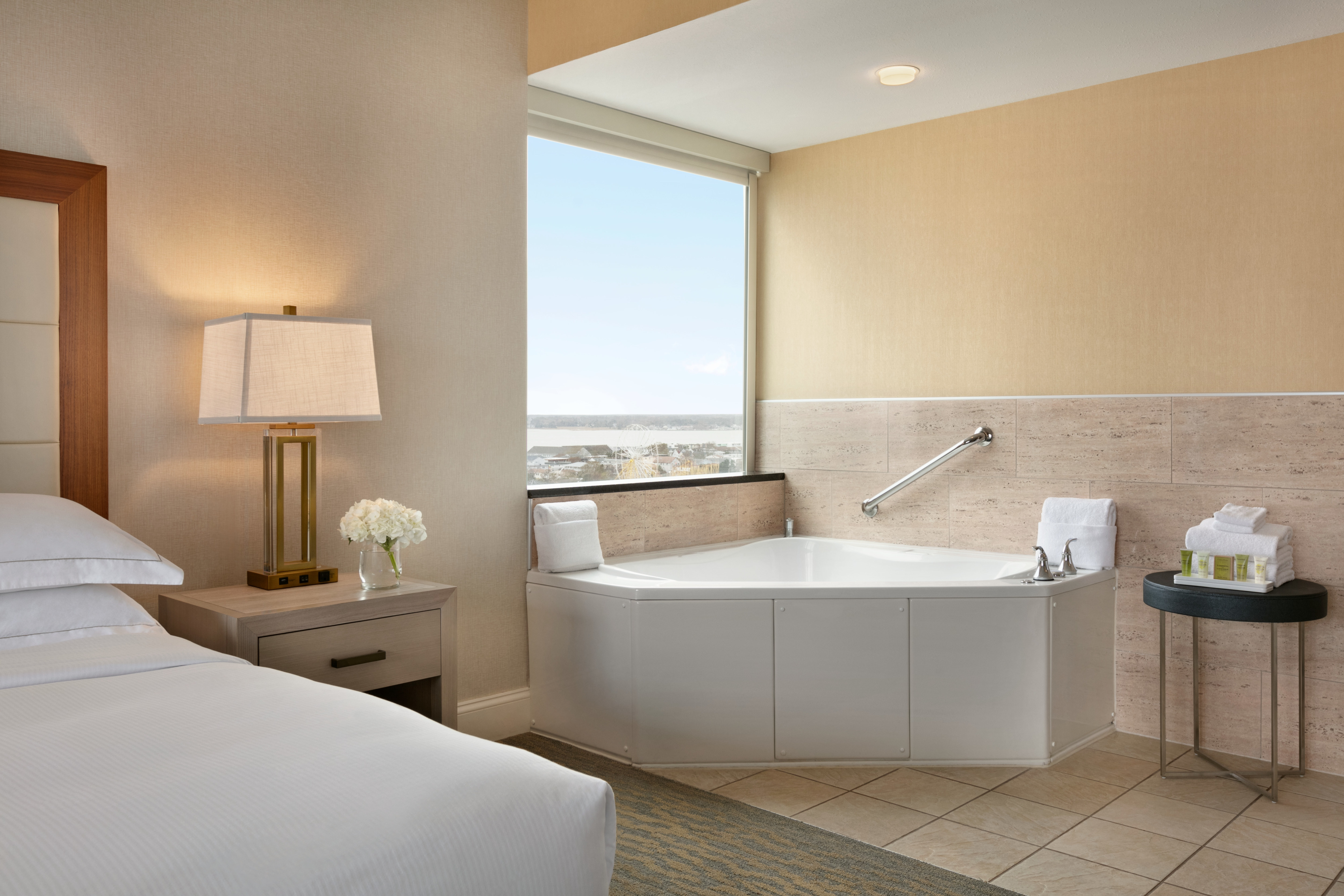 Guestroom with King Size Bed, Bedside Table, and Spa Tub with Ocean Outside View