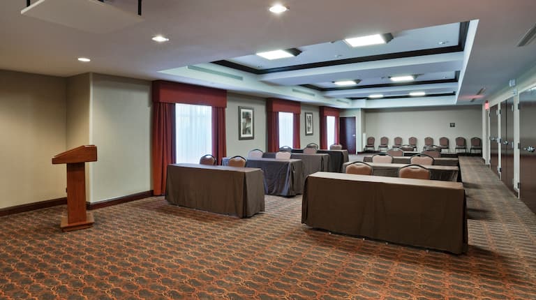 Classroom Setup in Meeting Room With Tables and Chairs Facing Podium
