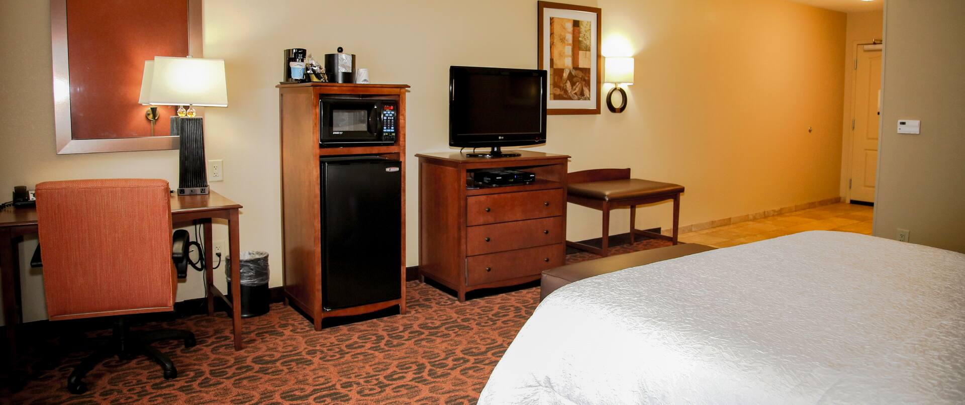 King Bed, Work Desk, Hospitality Center, TV, Wall Art, and Entry in Guest Room