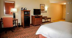 King Bed, Work Desk, Hospitality Center, TV, Wall Art, and Entry in Guest Room