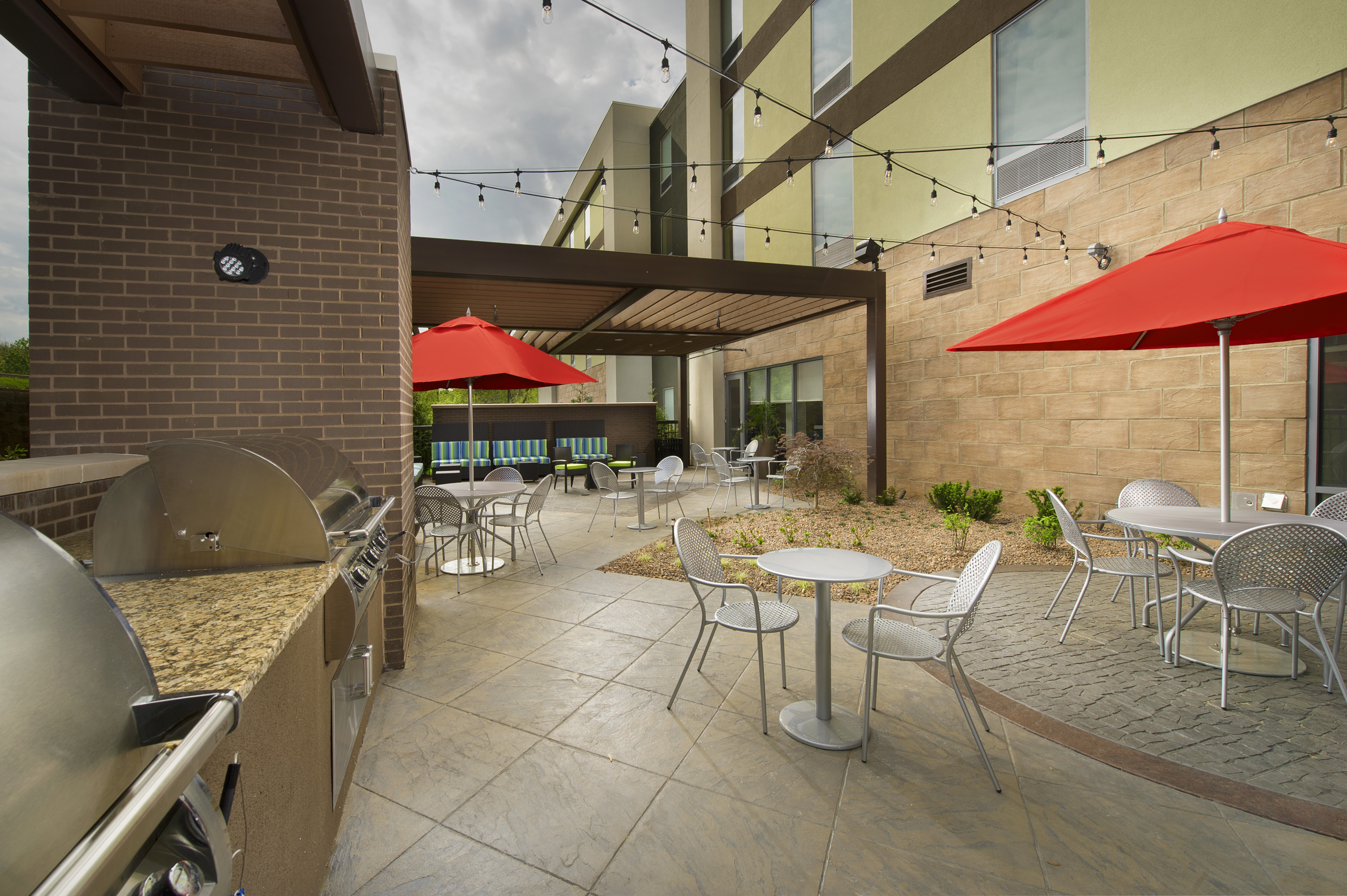 Outdoor Patio Seating Area with Chairs, Tables, Umbrellas and BBQ Grill