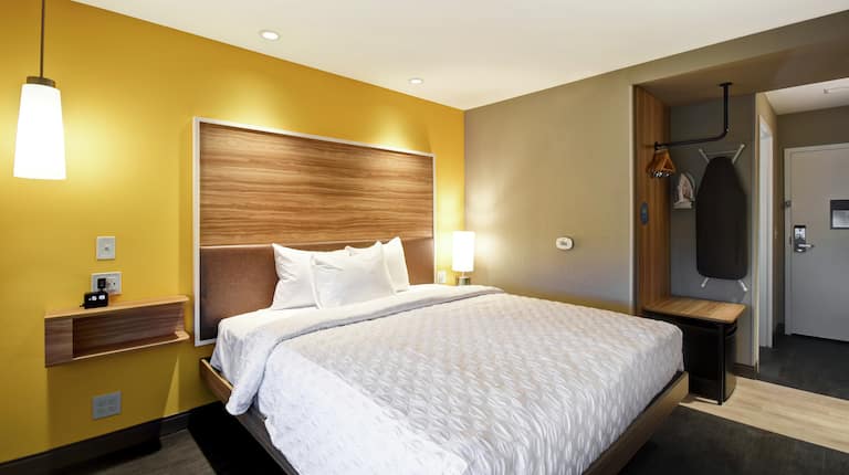 One King Bed Guest Bedroom with Wall Mounted Iron Board