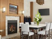 Spacious Hilton Garden Inn hotel lobby featuring large table with ample seating, beautiful fireplace, and stylish design.