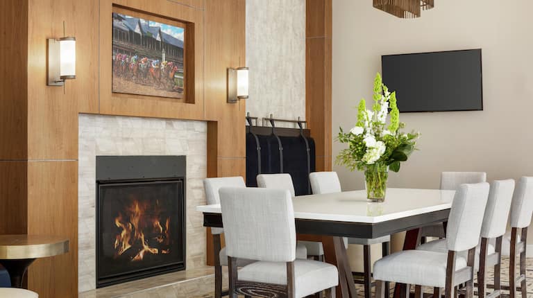 Spacious Hilton Garden Inn hotel lobby featuring large table with ample seating, beautiful fireplace, and stylish design.