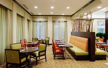 Tables, Chairs, Booth Seating, and Windows With Sheer Drapes in Great American Grill