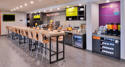 Breakfast serving and dining area with coffee, juice, cereals, oatmeal, fruits, and dining amenities