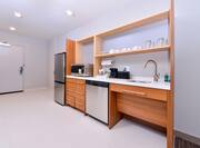 Accessible kitchenette with fridge, microwave, dish washer, coffee maker, and sink