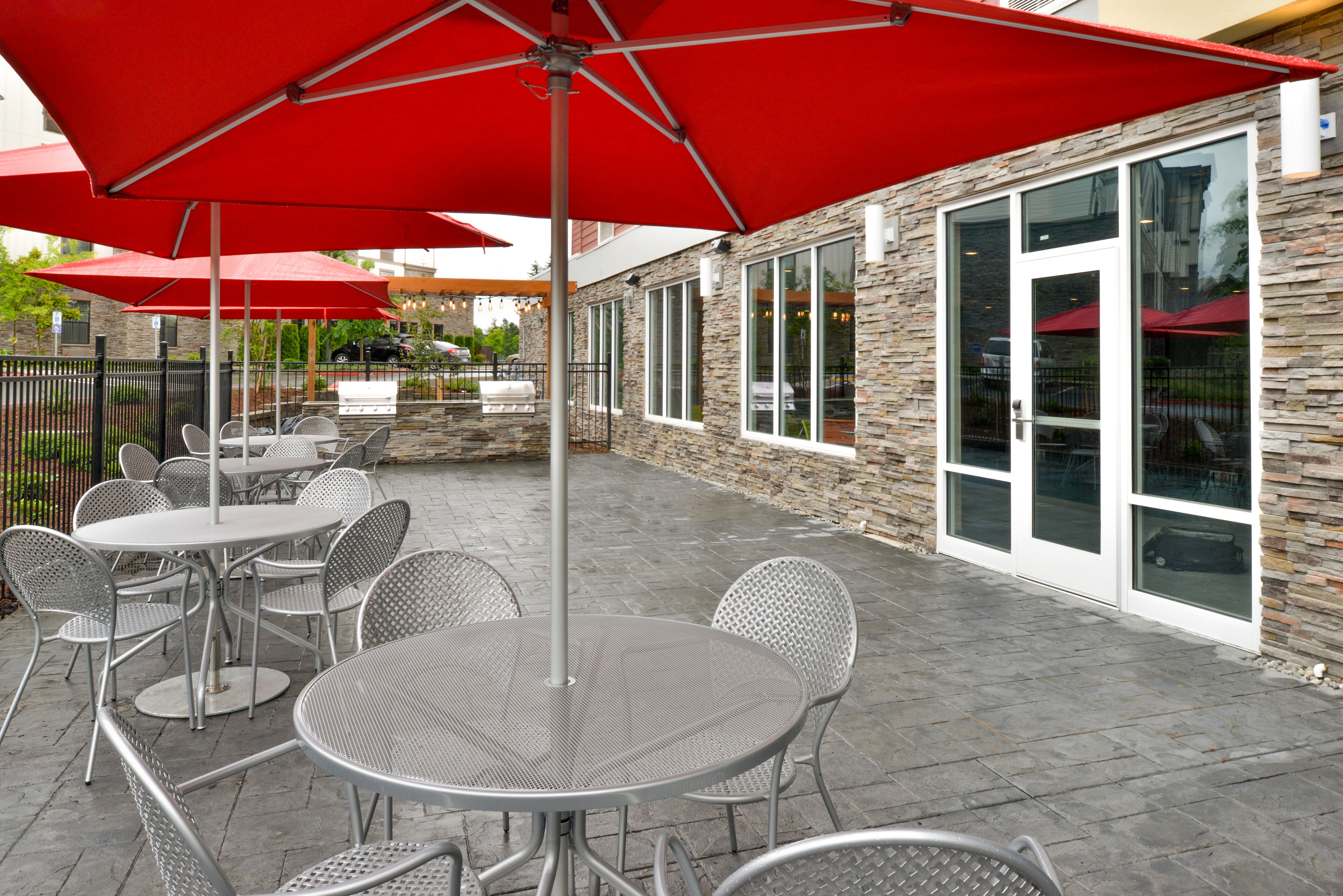 Hotel outdoor patio with BBQ grills and umbrella-covered dining tables