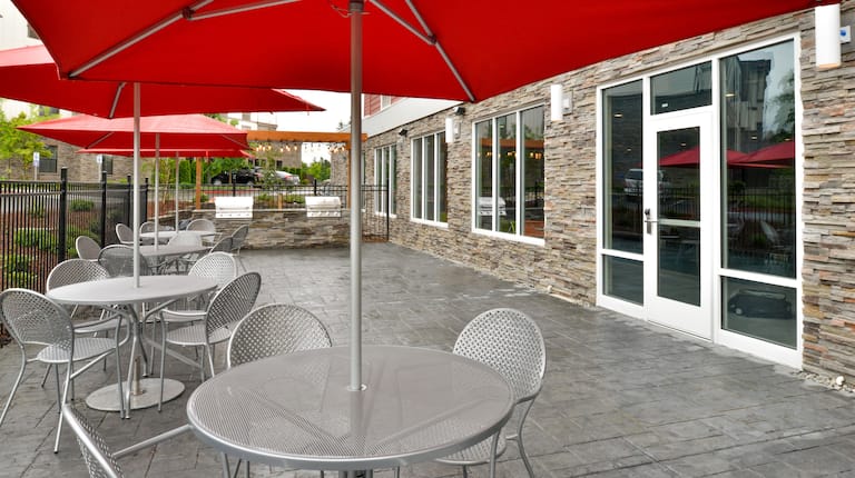 Hotel outdoor patio with BBQ grills and umbrella-covered dining tables