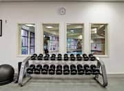 Fitness Room With Wall Art, Exercise Ball, Free Weights, Wall Clock Above Four Windows With View of Indoor Pool