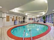 Indoor Swimming Pool and Whirlpool With Towel Station, Table, Chairs, Lounger, and Windows