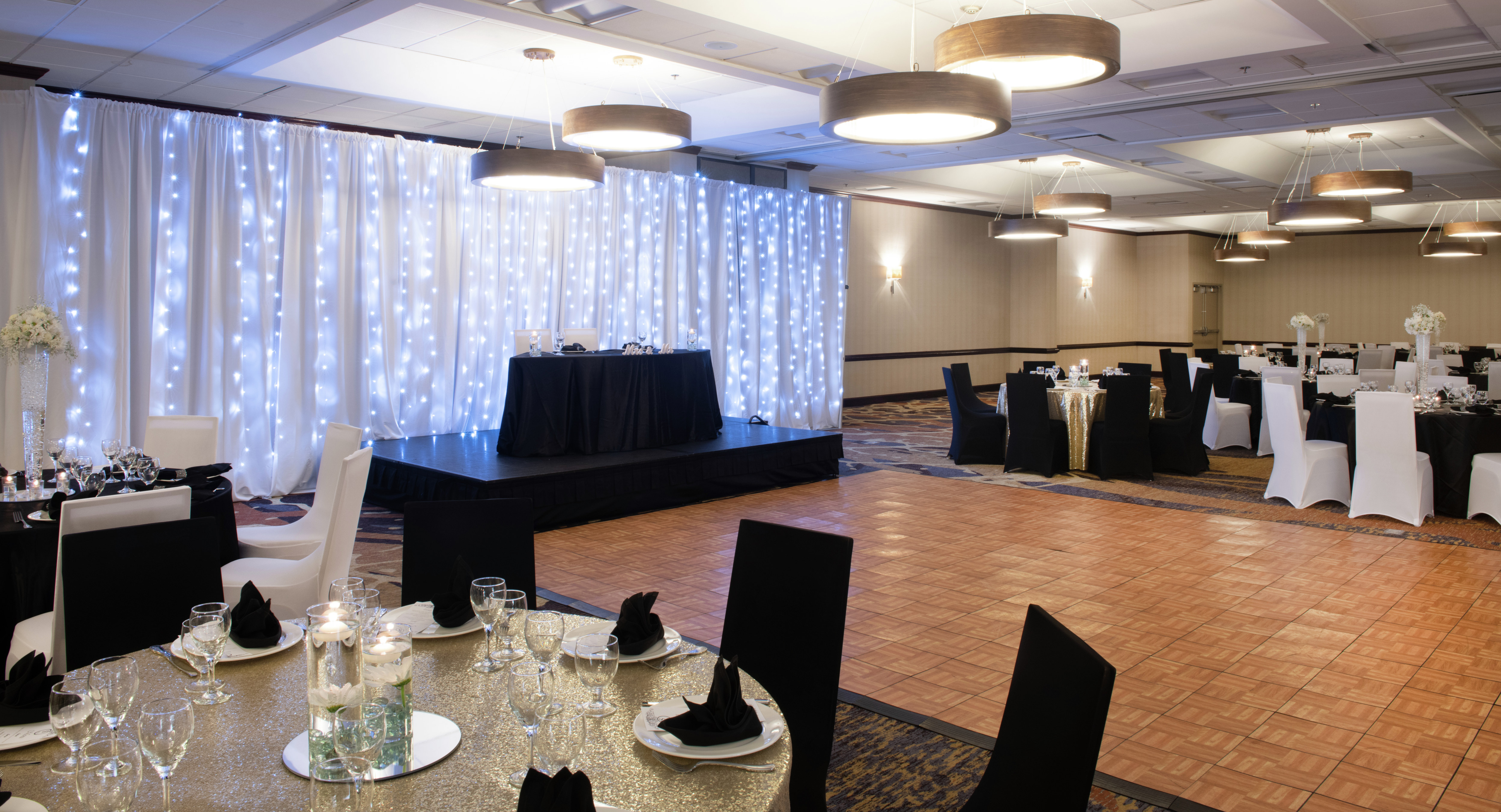 Ballroom setup with round tables in black and white for a banquet