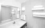 Tub Reflected in Large Vanity Mirror, Sink, and Fresh Towels in Standard Bathroom 