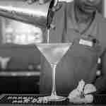 Baarimikko kaataa cocktailin ravistelijasta merinäköalabaarissa.