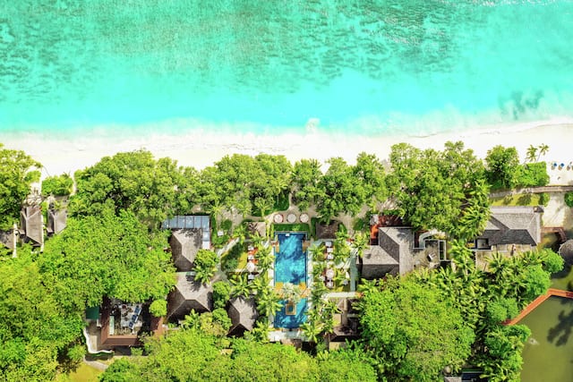 Aerial view of hotel exterior with pool by the beach