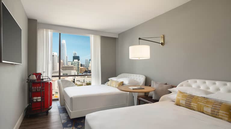 Guestroom with beds and city view from large window