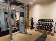 Fitness Center With Large Mirror, Weight Machine, Free Weights, and Bench