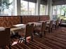 Tables, Chairs, and Booth Seating by Large Windows at the Garden Grille and Bar