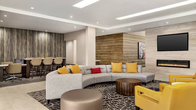 Spacious hotel lobby featuring comfortable seating, stylish design, and work area.