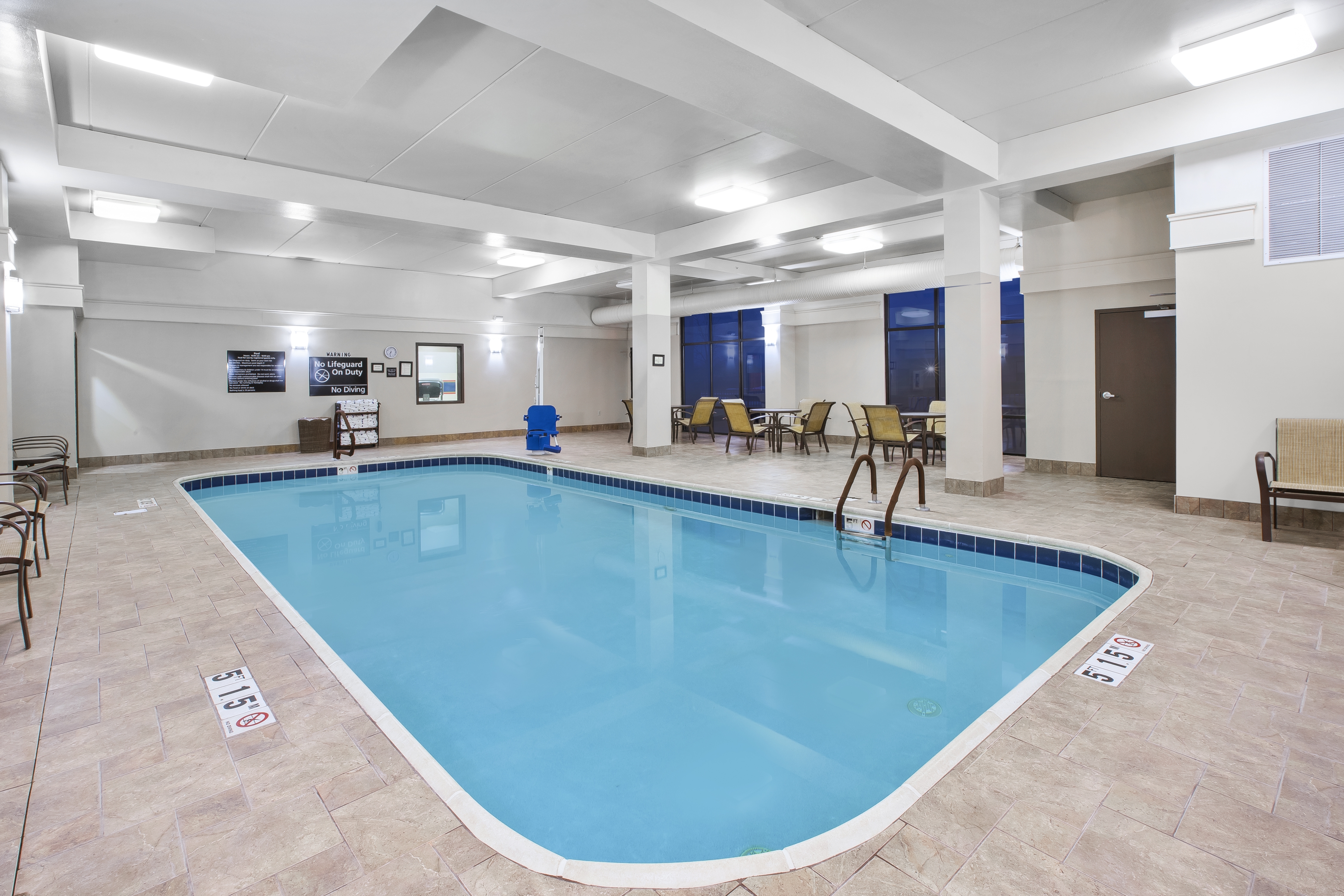 Indoor Pool With Tables and Chairs on Pool Deck