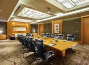 a long boardroom table with leather chairs