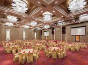 round banquet tables in a ballroom with two presentation screens