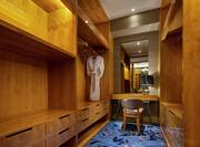 a walk-in closet with wood shelves, drawers and a vanity seat with mirror