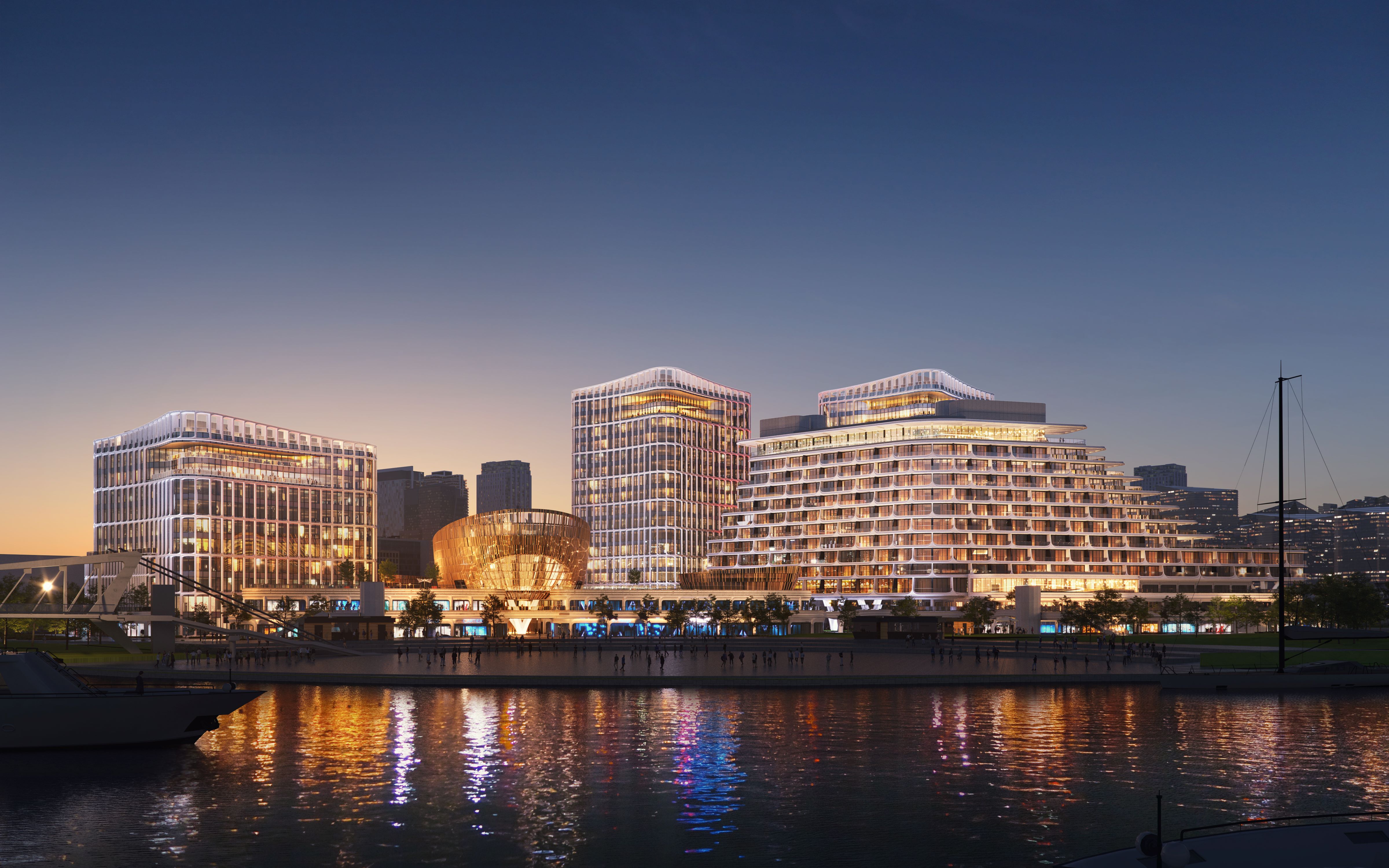 View of a Hotel Exterior next to a Large River at Night