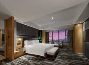 Deluxe Suite Bedroom with Large Bed and City View