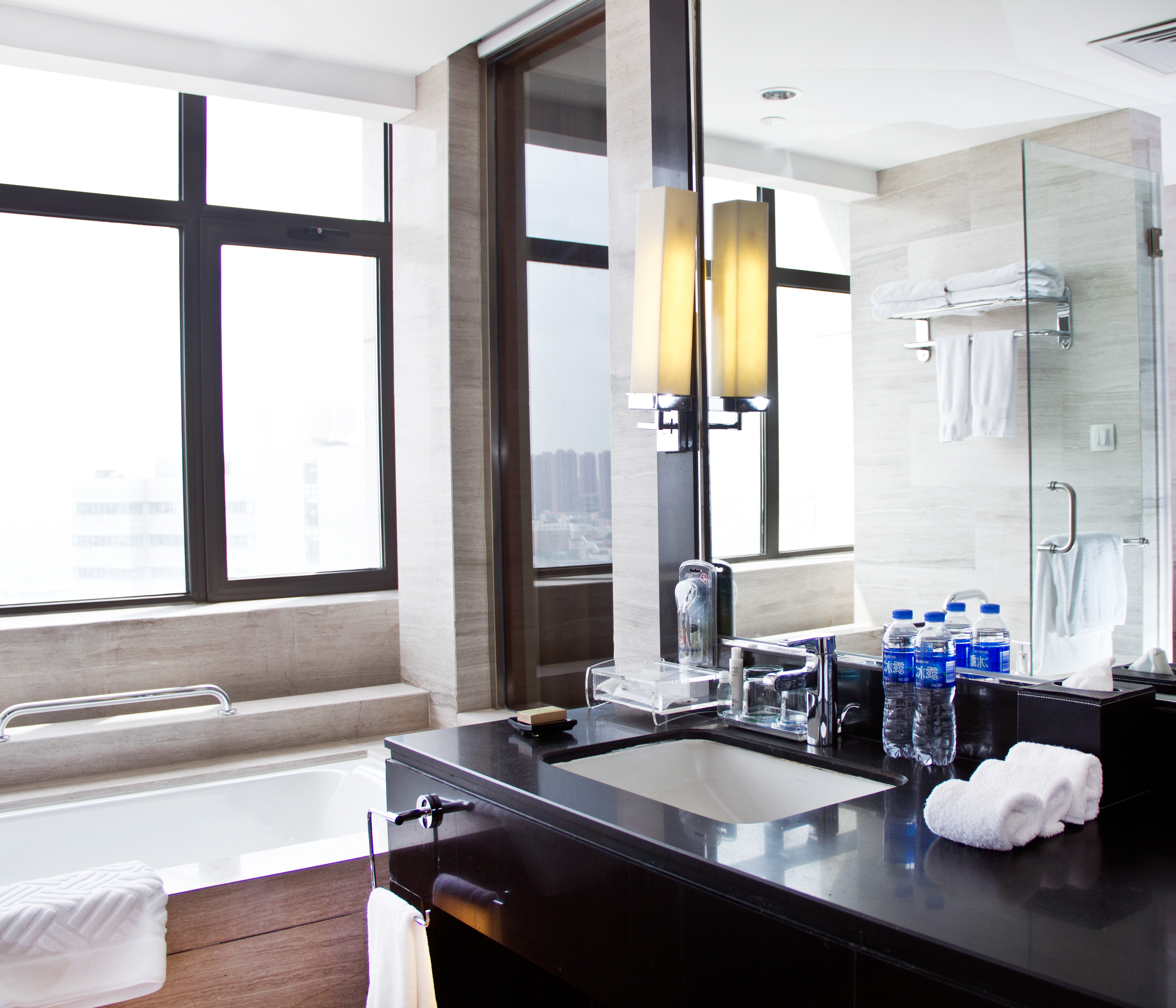 King executive bathroom vanity mirror, sink, hand towels, tub, and window