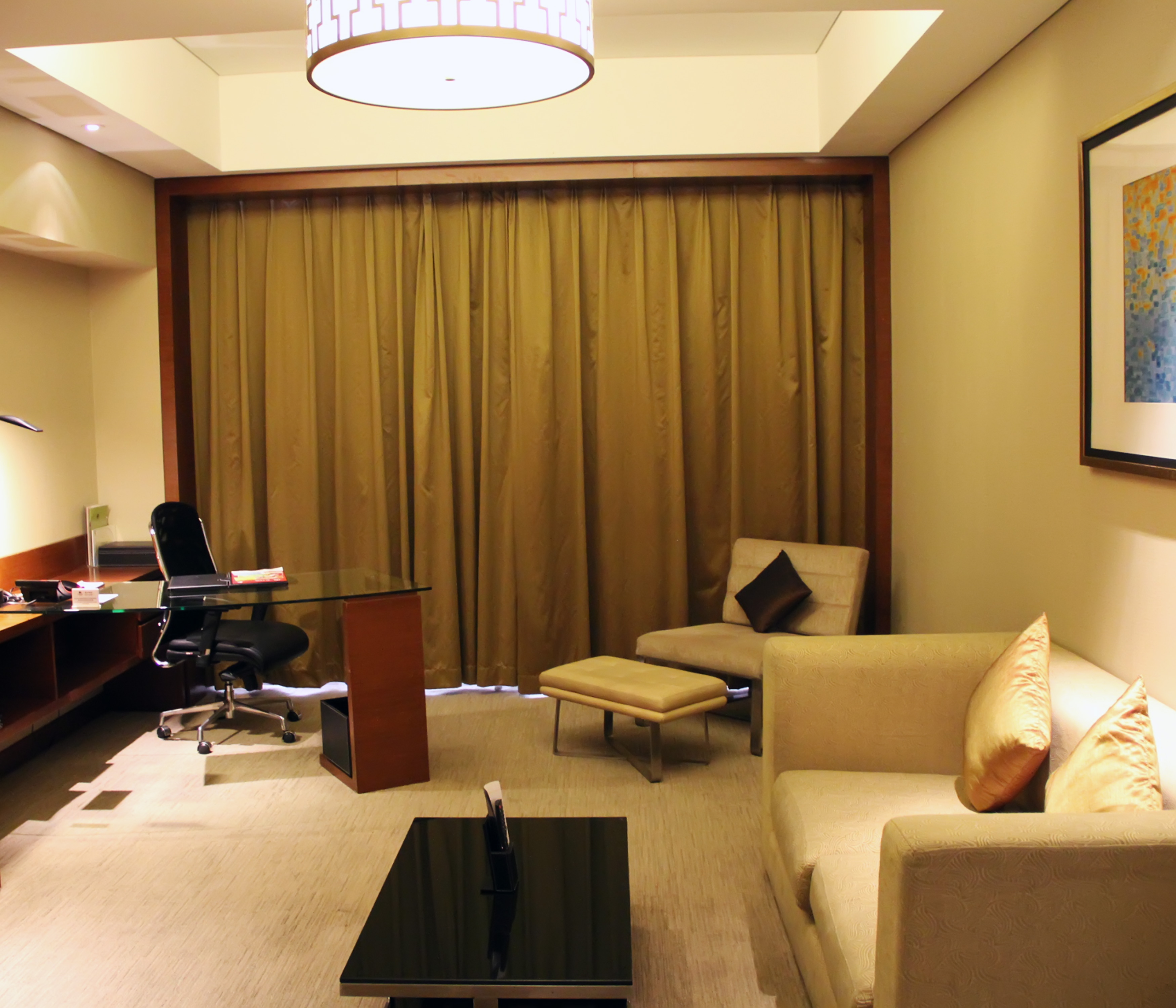 Superior suite living room with sofa, soft chair, ottoman, coffee table, and work desk