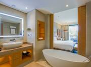 bathroom with tub and king bed