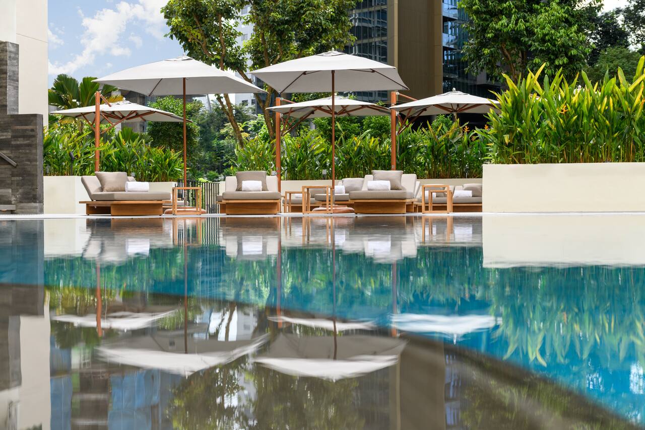 Outdoor pool with comfortable seating and umbrellas