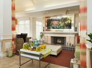 Soft Seating Around Fireplace WIth Wall Art, and Beverage Station in Lobby Lounge Area