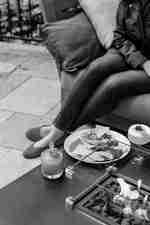 ผู้หญิงกําลังผ่อนคลายอยู่ด้านนอก พร้อมเครื่องดื่มและขนมขบเคี้ยว