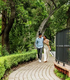 Man and woman walking on path outside hotel