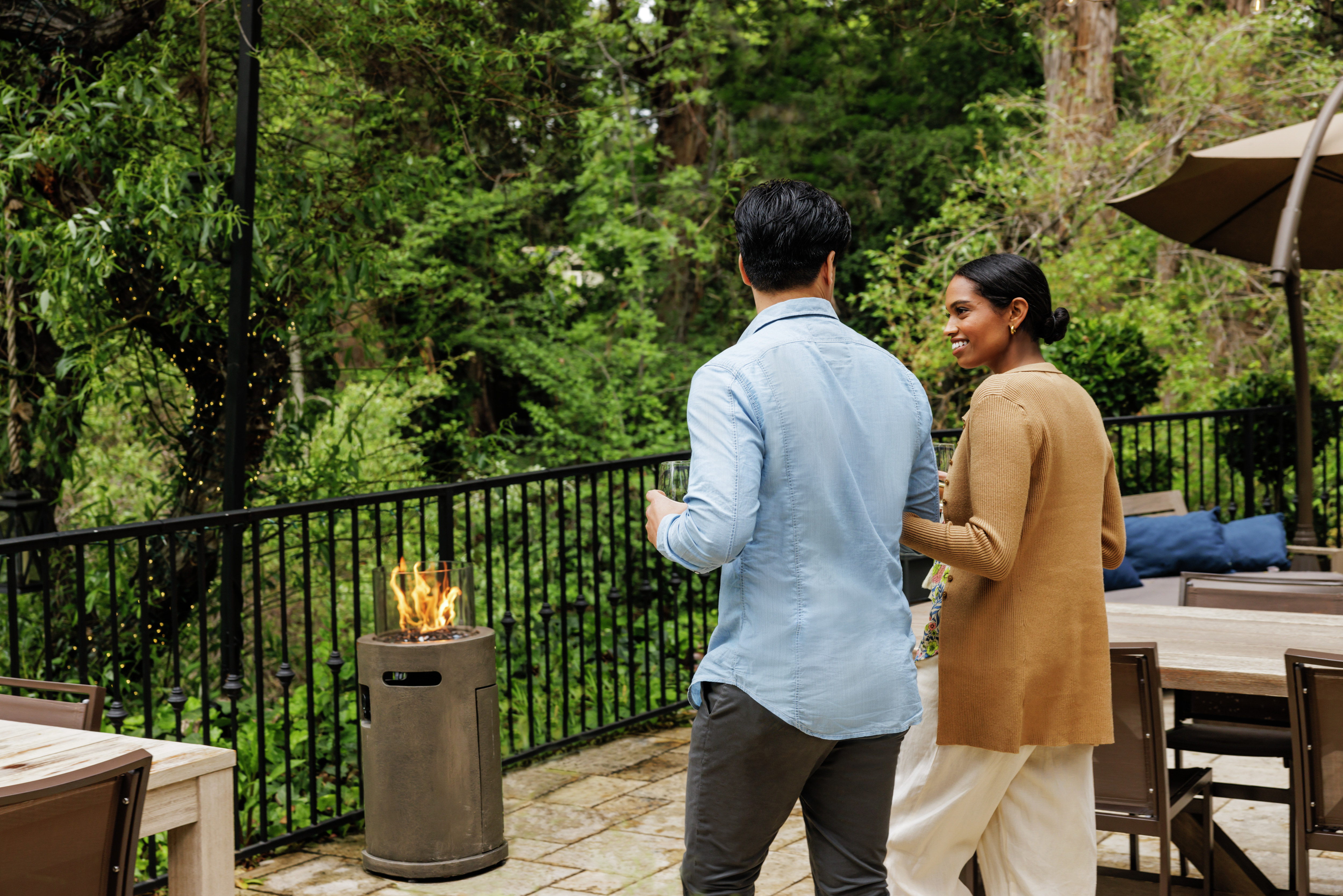 Man and woman on exterior patio with fire pit