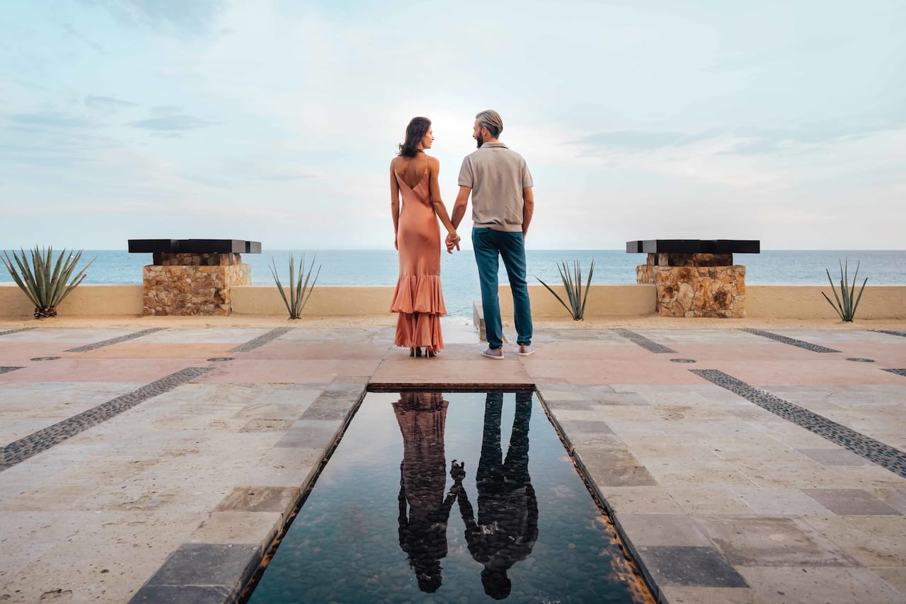 Un homme et une femme tenant les mains avec la mer en arrière-plan