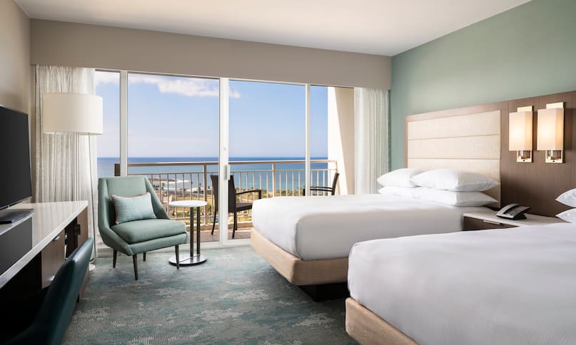 Dos camas dobles en habitación con vista al mar